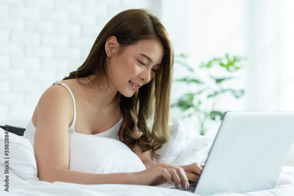 Beautiful Attractive Asian young woman lying on bed and using computer laptop for using social media and shopping online relax in cozy bedroom in holiday,Lifestyle in home Concept Beautiful Attractive Asian young woman lying on bed and using computer laptop for using social media and shopping online relax in cozy bedroom in holiday,Lifestyle in home Concept
