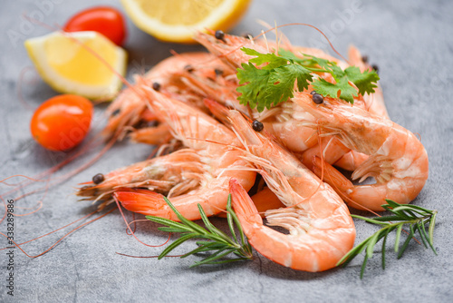 fresh shrimp on dark plate with ingredients herb and spices - cooking seafood shrimps prawns served on a table background