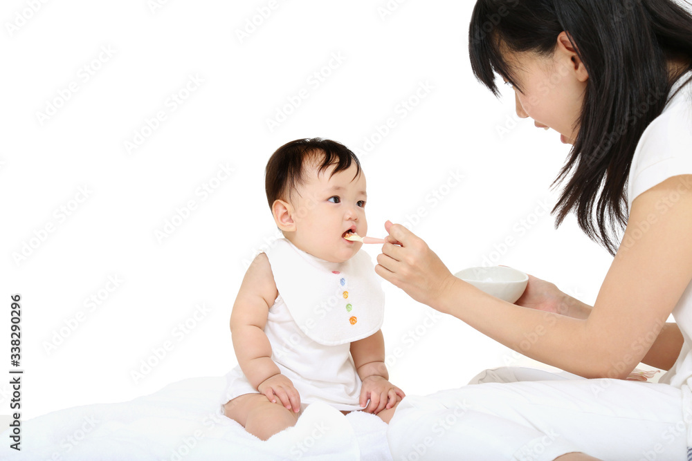 赤ちゃんに離乳食を食べさせる若い母 赤ちゃんに離乳食を食べさせる若い母
