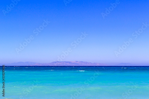 simply landscape with sea turquoise color , mountains on the horizon and gradient blue sky.Horizon line between calm mediterranean sea and clear blue sky