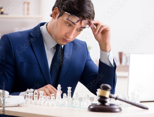 Young lawyer playing chess to train his court strategy and tacti photo