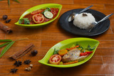 traditional indonesian tilapia soup on a green plate over wooden background.