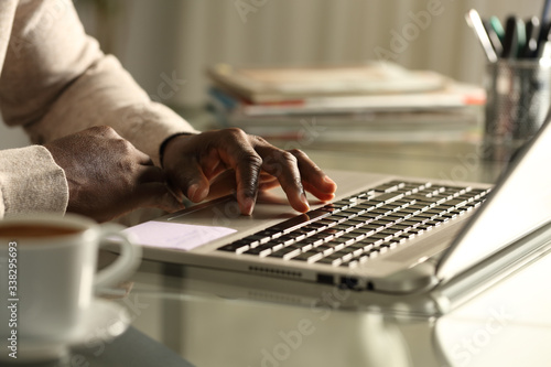 Obraz na plátne Black man hand using touchpad on laptop at night