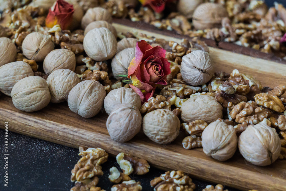 Shelled and shelled walnuts on a wooden board on the table. Healthy nutrition, vegetarianism, diet.