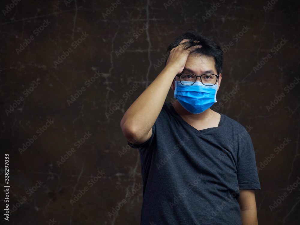 Portrait of a sick men with surgical medical mask headache. Prevention of bacterial infection Corona virus or Covid 19. Health care concept. Portrait of a sick men with surgical medical mask headache. Prevention of bacterial infection Corona virus or Covid 19. Health care concept.