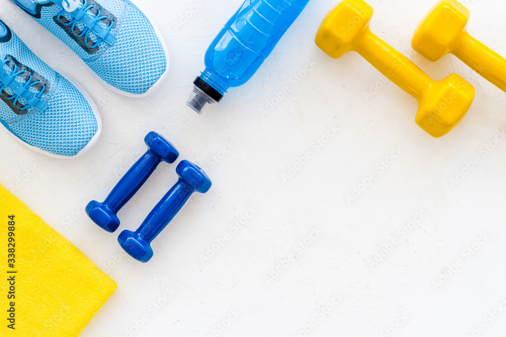 workout accessories. Sneakers, dumbbells, towel on white background top view copy space workout accessories. Sneakers, dumbbells, towel on white background top view copy space