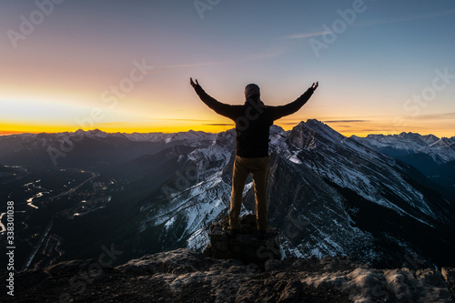 Man posing on top of the mountain during the sunrise. EEOR, Canmore, Canada