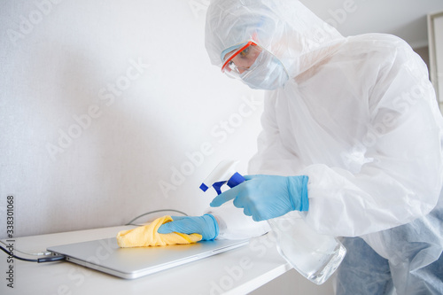 Cleaning service disinfects office Technics from coronavirus and germs, antiseptic processing computer