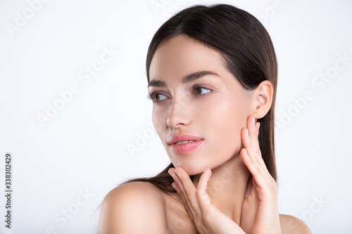 Portrait of beautiful young brunette woman with clean face. Beautiful face of young adult woman with clean fresh skin - isolated on white. Front portrait of woman with beauty face. .Beauty concept