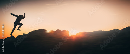 Banner, web page or cover template of Athlete run on the top of the hill during sunset - motivation, sport, energy concept photo with copy space. Copy space and panoramic ratio