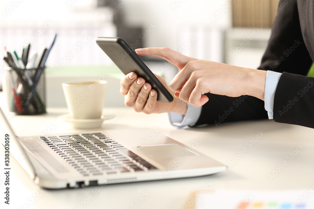 Executive hands with laptop checking phone Executive hands with laptop checking phone