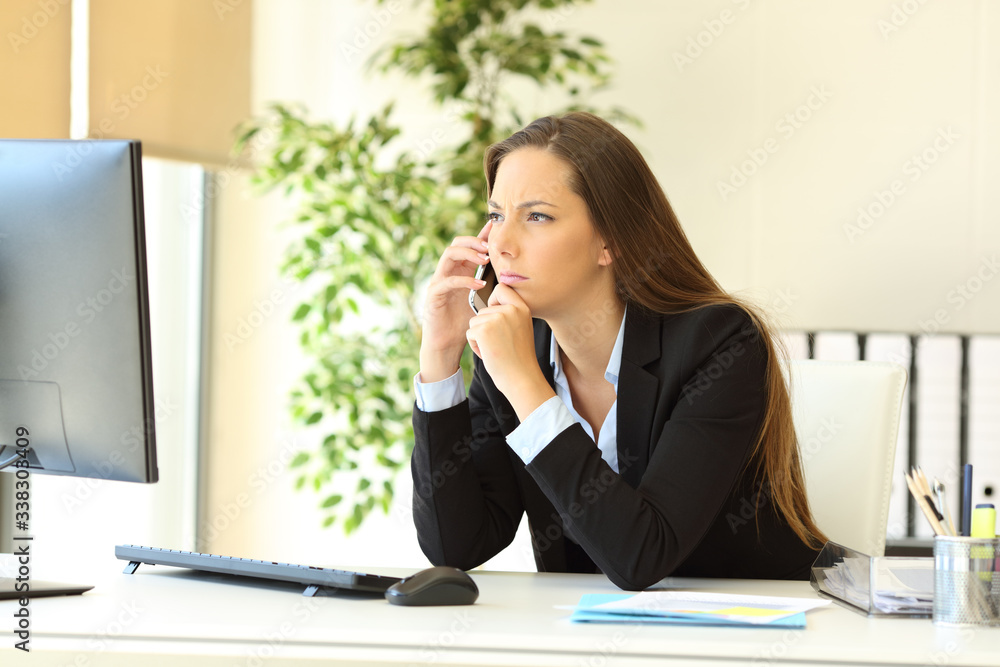 Pensive executive talking on phone with computer Pensive executive talking on phone with computer
