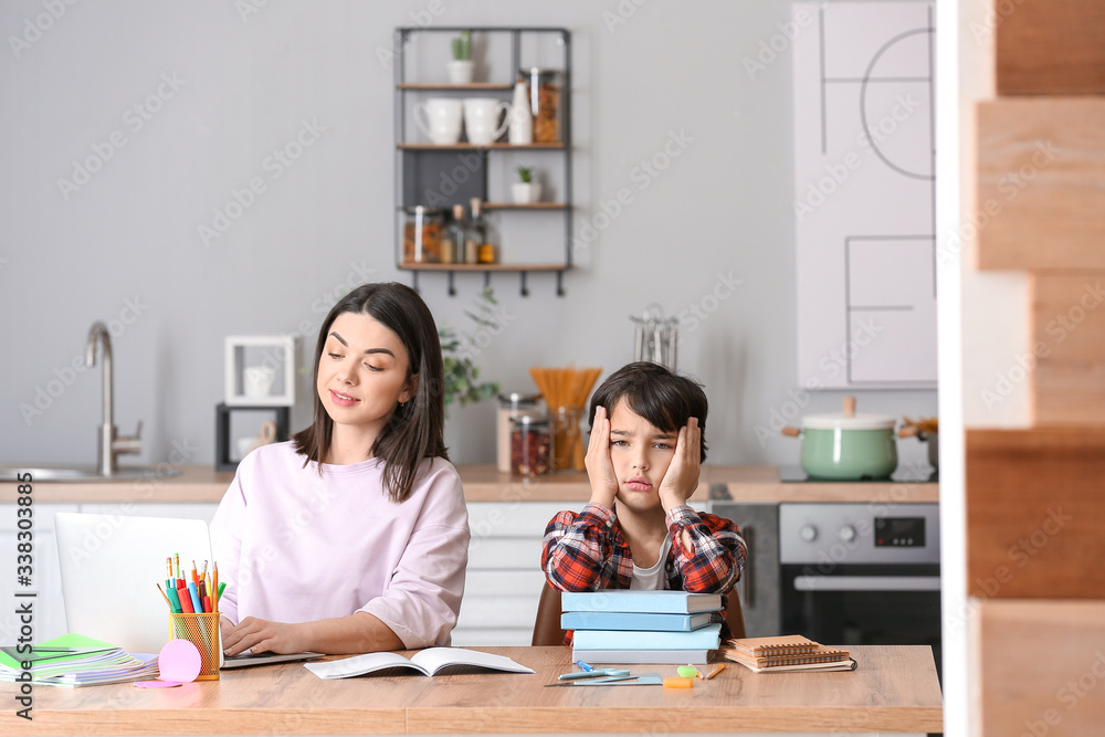 Mother with little boy unwilling to do homework in kitchen Mother with little boy unwilling to do homework in kitchen