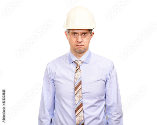 A disgruntled man engineer in a white construction helmet, shirt, tie offended, looking into the camera. Isolated © Arsentyev Vladimir