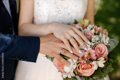 Hands and rings on wedding bouquet