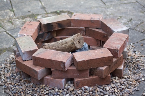 Home made brick built fire pit or barbecue with logs