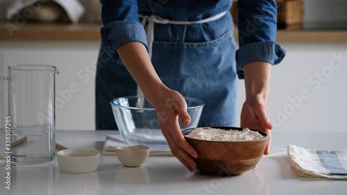 A woman pours flour into a bowl. Sprinkle powder with flour. Slow motion. 4K.