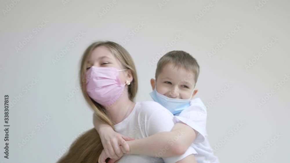 Brother and sister on white background having fun and wearing mask during Covid-19 or Coronavirus outbreak Brother and sister on white background having fun and wearing mask during Covid-19 or Coronavirus outbreak