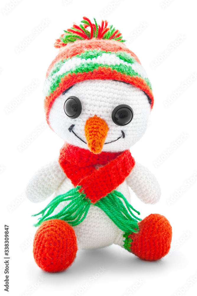 Handmade crochet snowman doll isolated on white background with shadow reflection. Playful crochet snow-man toy with orange scarf, sitting on white underlay. Knitted snowman plaything. Christmas theme Handmade crochet snowman doll isolated on white background with shadow reflection. Playful crochet snow-man toy with orange scarf, sitting on white underlay. Knitted snowman plaything. Christmas theme