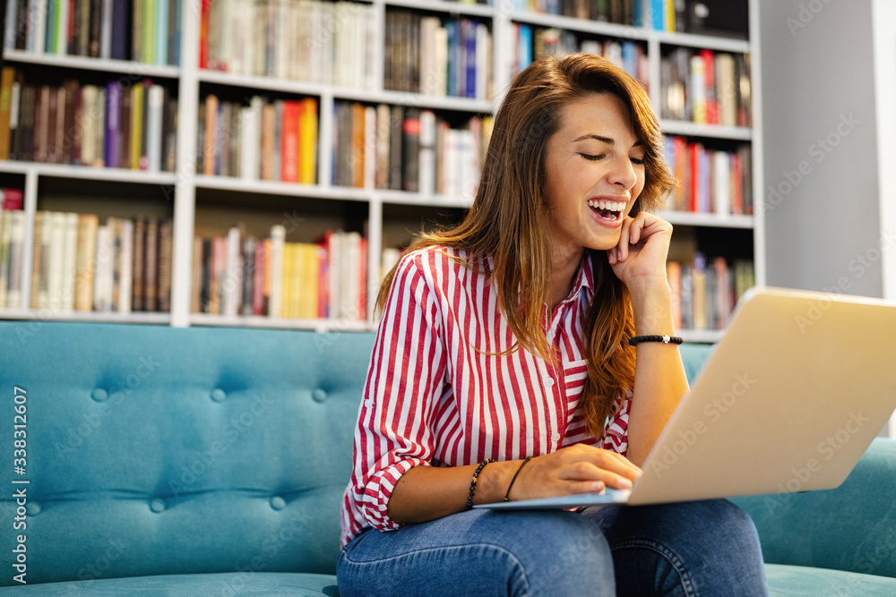 Happy young woman receiving good news on her notebook