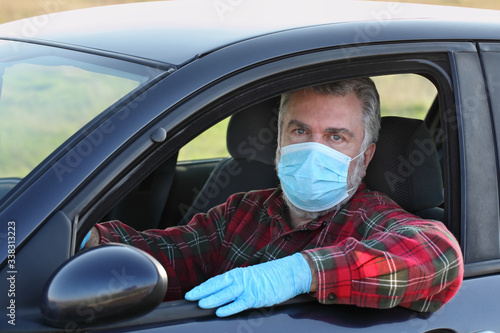 Protected driver in car wearing mask and gloves, corona virus protection