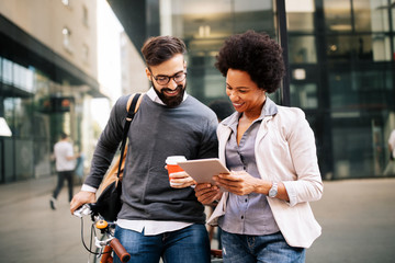 Business people discussing and smiling while walking together outdoor
