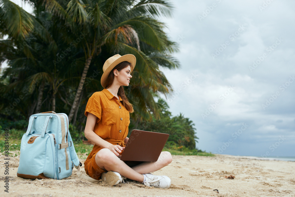 woman with laptop on the beach