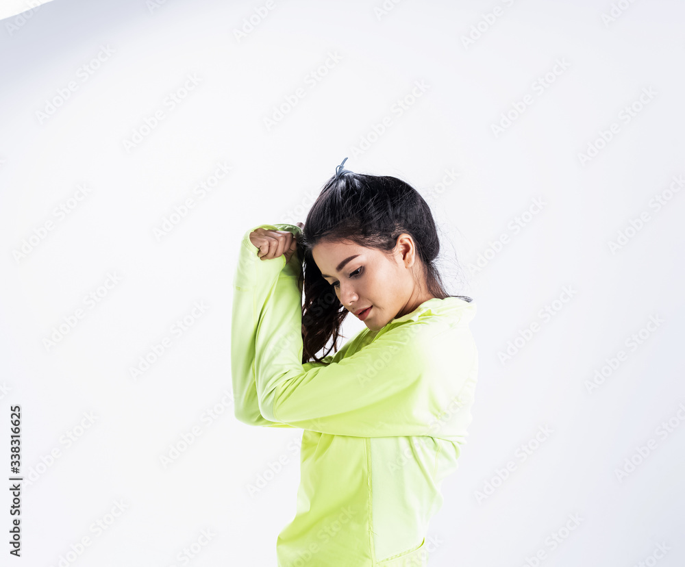 The beautiful lady wearing green jacket,put hand touch her hair,model posing on background,with happy feeling The beautiful lady wearing green jacket,put hand touch her hair,model posing on background,with happy feeling