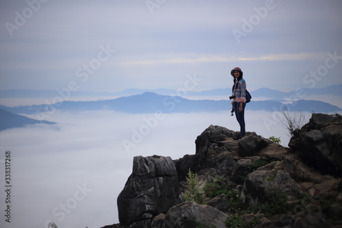 Woman standing and enjoying the view of Doi Pha Tang Chiang Rai, Thailand