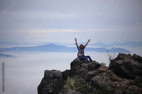 Woman sitting and enjoying the view of Doi Pha Tang Chiang Rai, Thailand