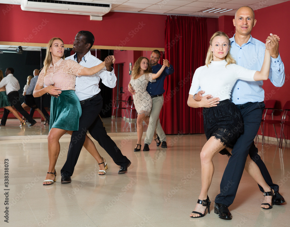Adult couples dancing  salsa dance together  in modern studio