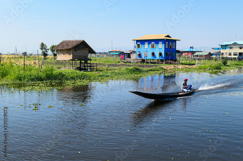 Floating village on the lake. Houses on the lake in the water with floating garden. Wooden boat on the river.