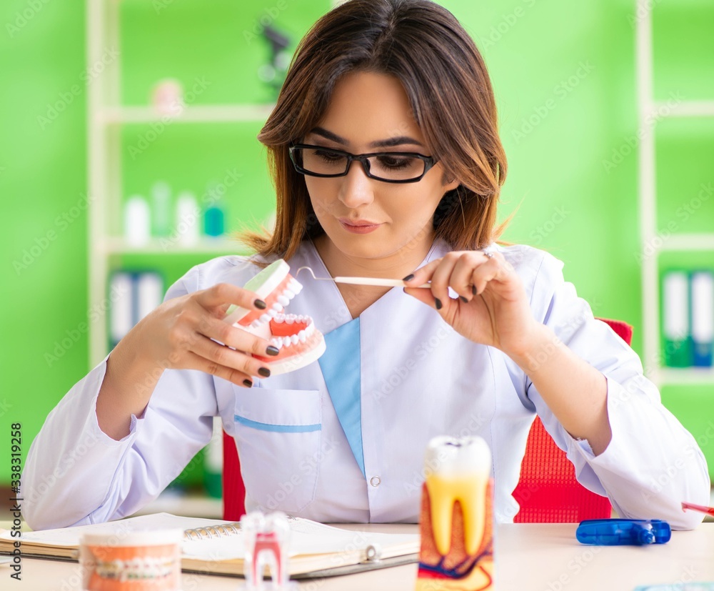 Woman dentist working on teeth implant Woman dentist working on teeth implant