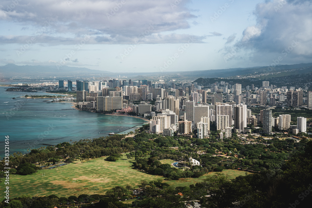 Fototapeta premium Dramatic views of Waikiki from the Diamond Head Crater Hike summit on a bright but cloudy day.