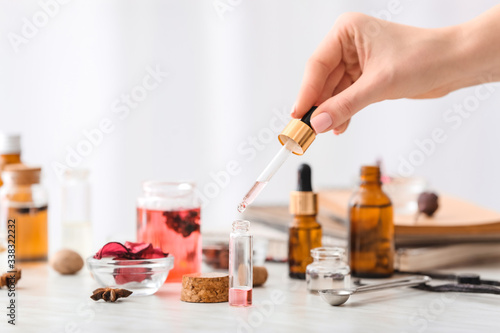 Woman preparing perfume on table photo