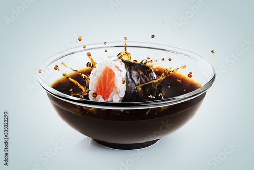Sushi maki drops in a bowl with soy sauce on light background. Splash of soy sauce.