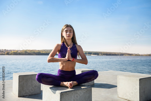 Young pretty fitness  woman doing yoga poses, streching in the nature. Healthy lifestyle.