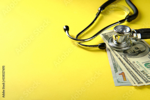 Doctor's stethoscope and banknotes, treatment expenses symbols photo