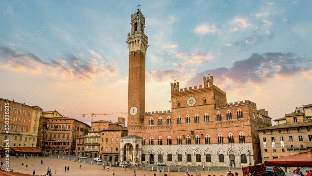 Siena, Toscana, Italy - September 2014: Amazing sunset overlooking the bell tower of Torre del Mangia
