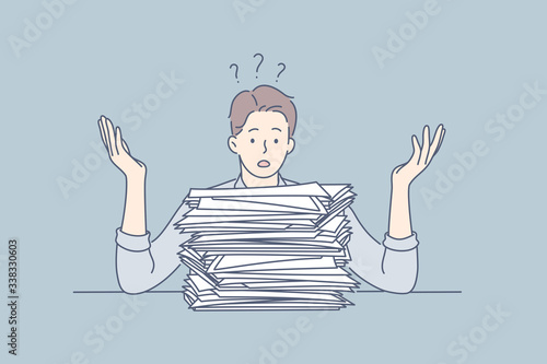 Overworking, depression, deadline, mental stress, business concept. Young frustrated upset businessman clerk manager, depressed boy looks at big pile of document. Fatigue because of overload deadline.