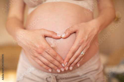 Wallpaper Mural Close up of husband and wife hand making heart shape on pregnant belly Torontodigital.ca