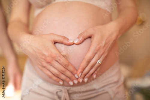 Wallpaper Mural Close up of husband and wife hand making heart shape on pregnant belly Torontodigital.ca