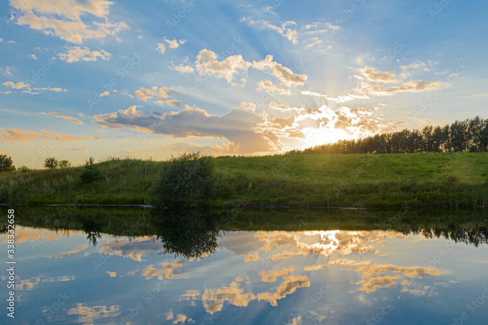 Summer evening landscape with reflection of clouds in the lake Summer evening landscape with reflection of clouds in the lake