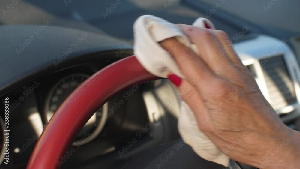 Woman disinfects steering wheel from cornavirus Woman disinfects steering wheel from cornavirus