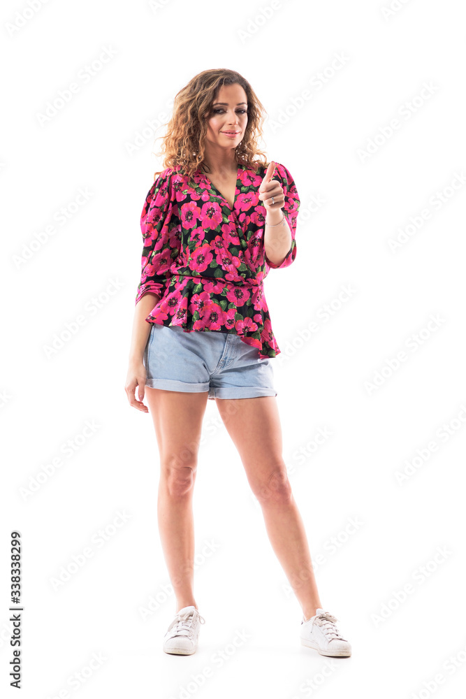 Confident happy young stylish woman in summer clothes showing thumbs up like hand sign. Full body isolated on white background. Confident happy young stylish woman in summer clothes showing thumbs up like hand sign. Full body isolated on white background.