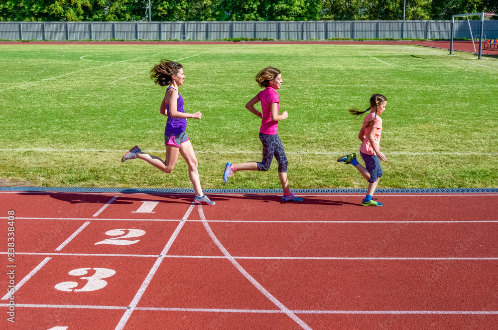 Fototapeta premium Family fitness, mother and kids running on stadium track, training and children sport healthy lifestyle concept