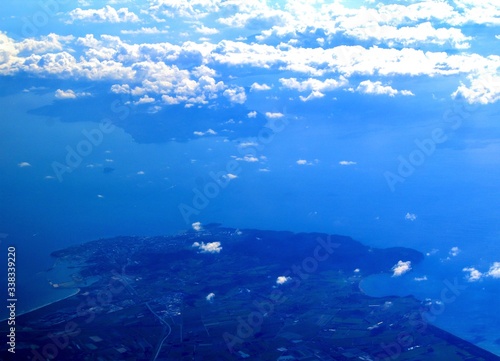 evocative image of the Italian sea coast seen from the plane with clouds in the background 