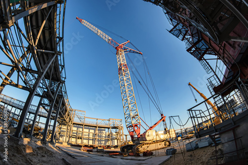 A self-propelled crawler crane stands on a construction site