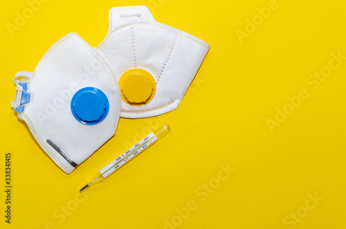 respirators and thermometer on a yellow background
