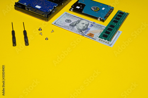 hard drives and replacement tools with dollars and memory on a yellow background